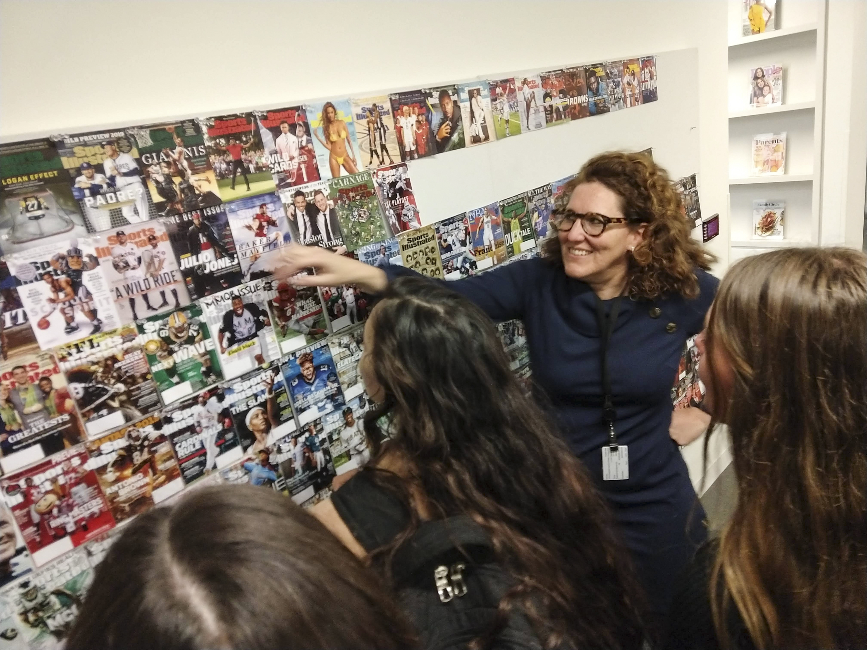 Sports Illustrated editor Marguerite Schropp Lucarell shows RIT students previous magazine covers she worked on.