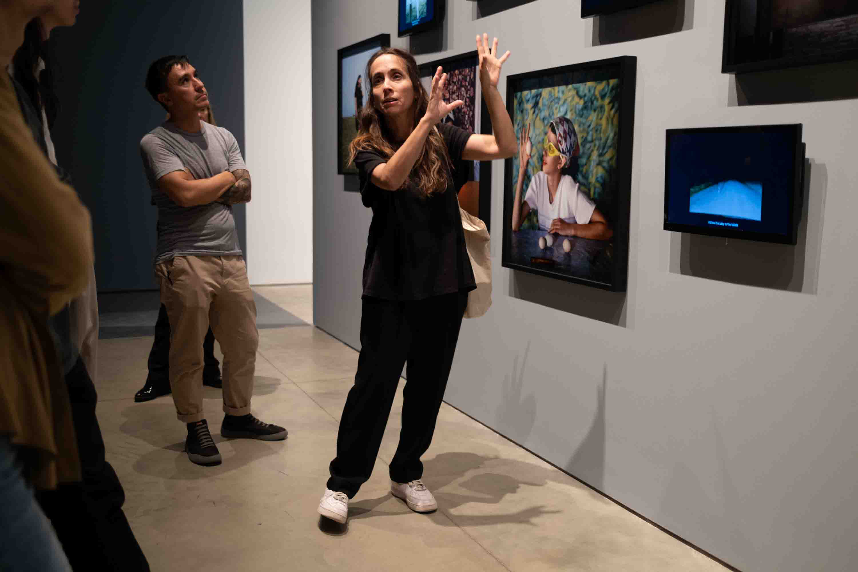 Alessandra Sanguinetti talks about photos on a gallery wall.