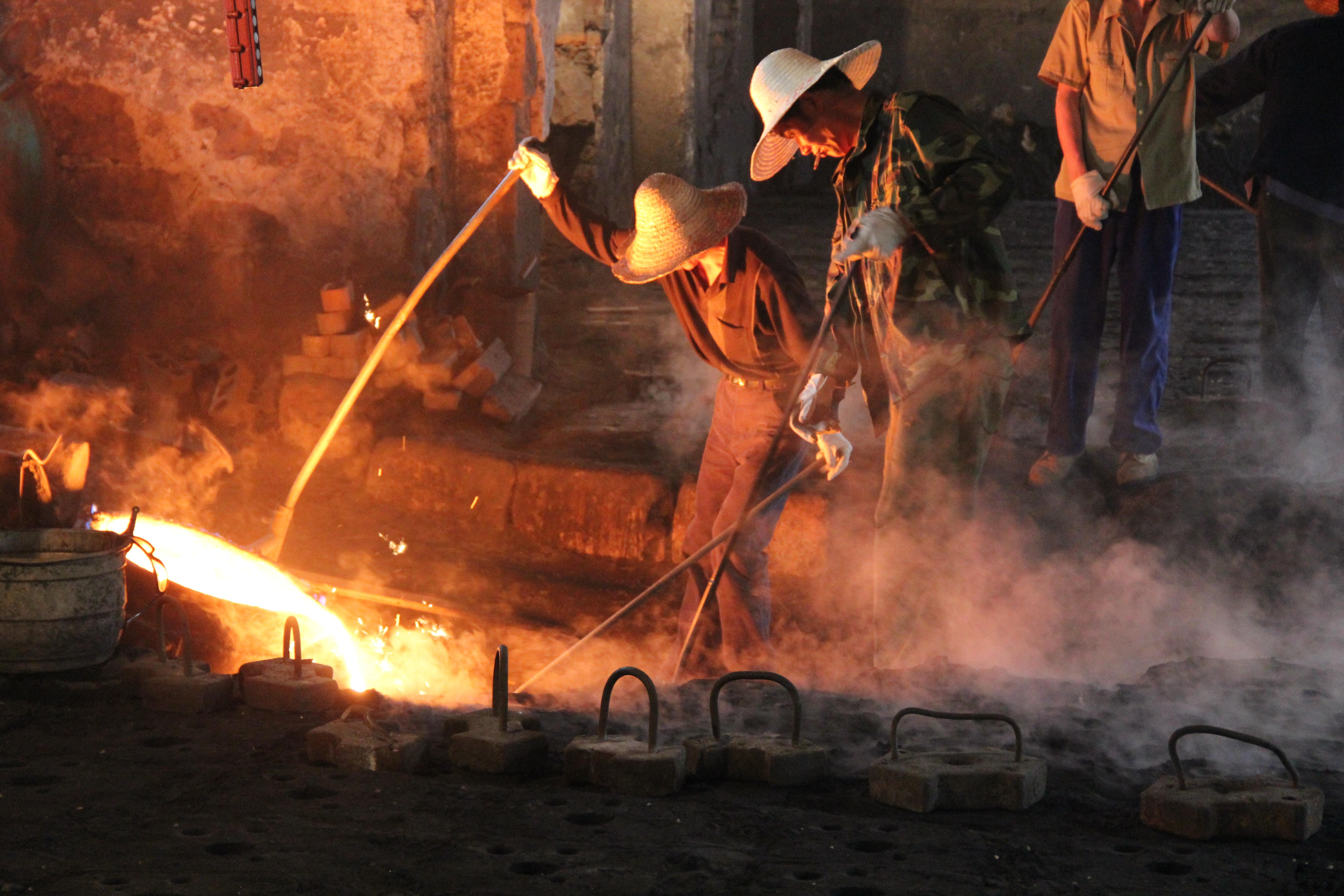 People work in a foundry near molten iron.