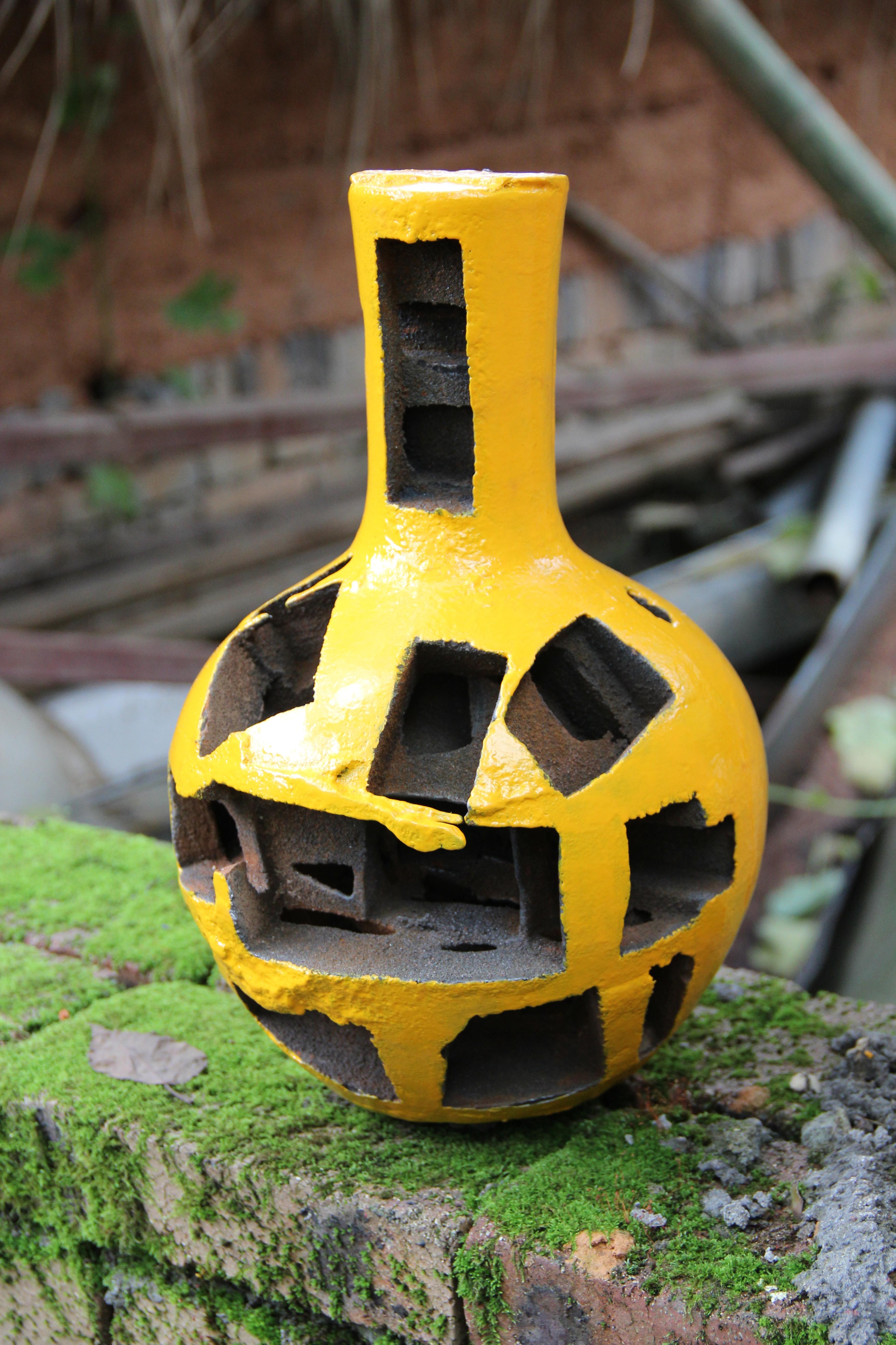 A yellow vessel with holes in it.