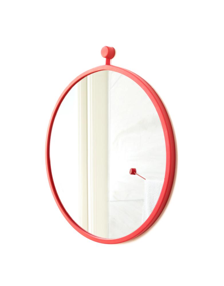A circular mirror with a red border.