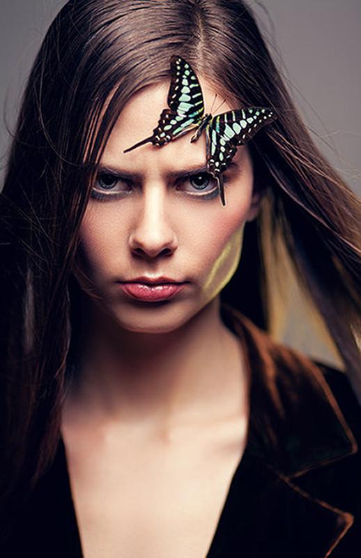 A portrait of a woman with a butterfly on her forehead.