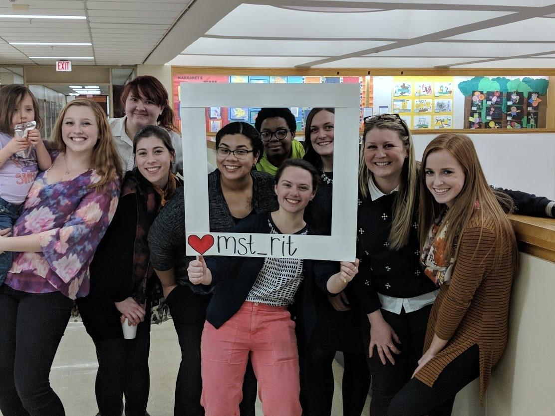 A group of women holding a frame that says mst_rit