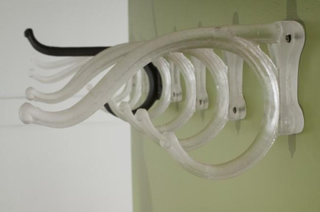 Glass hooks mounted on a wall.