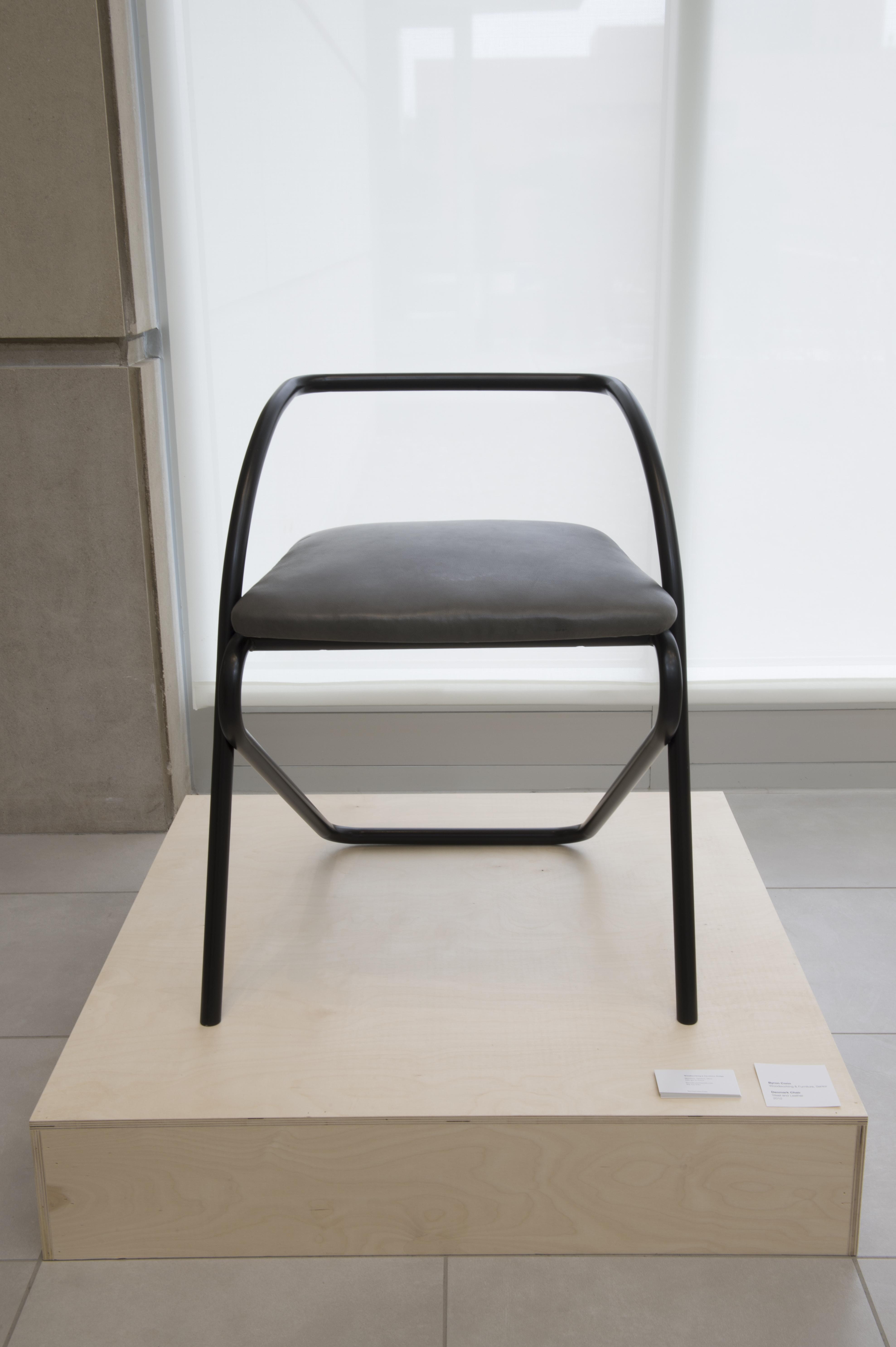 A black chair sits on display in University Gallery.