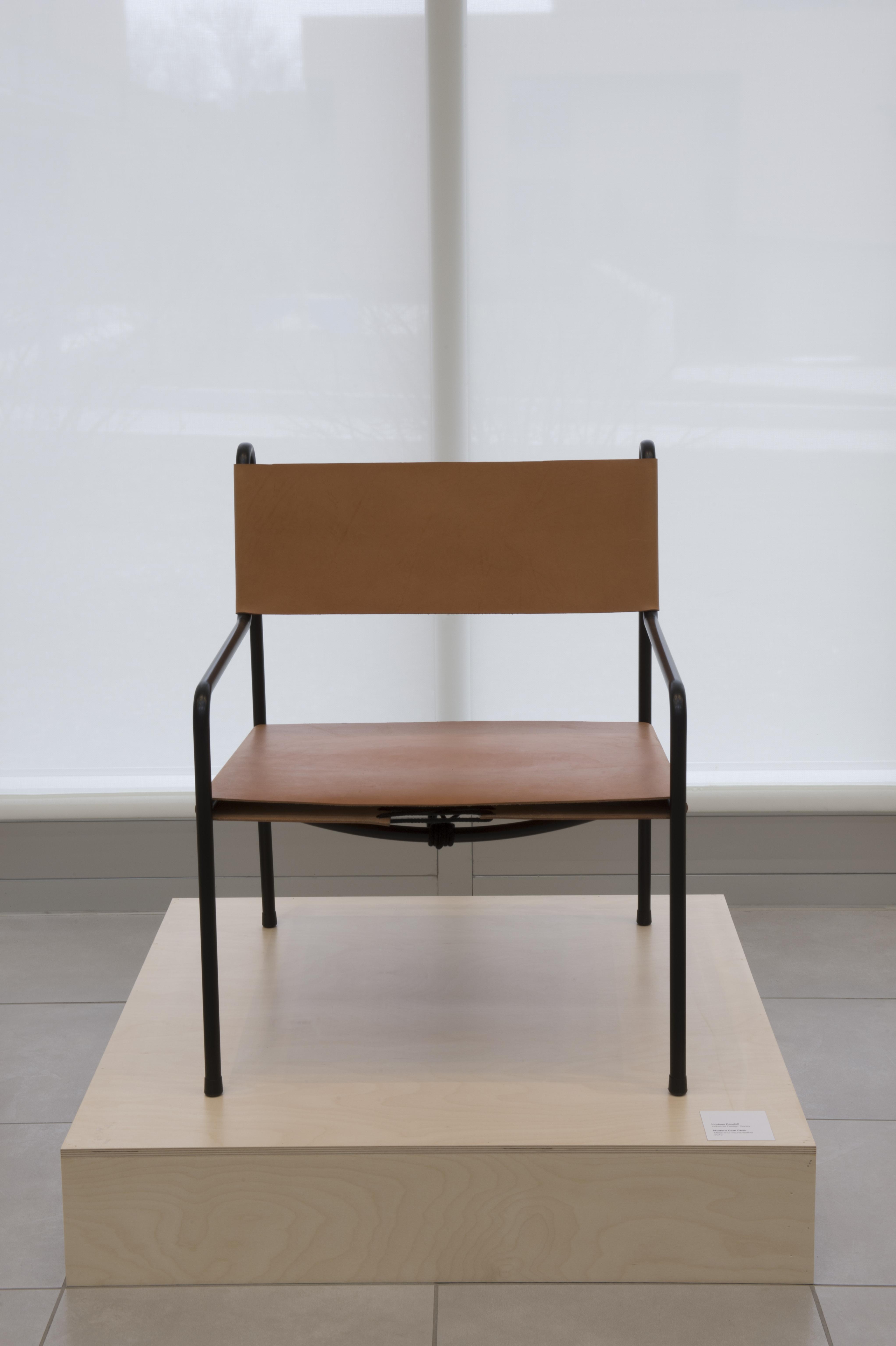 A dark wood chair on display in University Gallery.