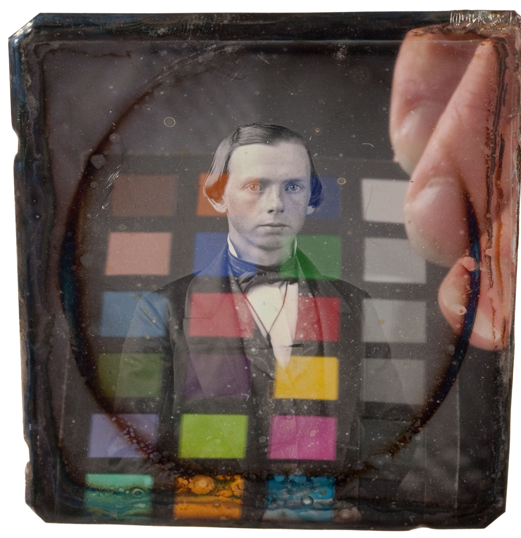 Daguerreotypes are highly reflective with a mirror-like surface. Shown here is a color checker and hand reflected in the surface of the plate. 